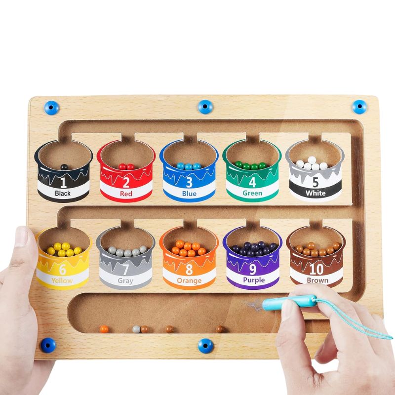 magnetic colour-sorting maze toy with a pen guiding beads into numbered paint-pot sections for learning colours and fine-motor skills.
